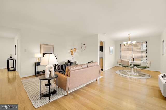 living room with a chandelier and light hardwood / wood-style floors