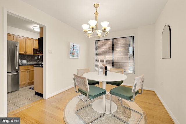 dining area with a chandelier, light hardwood / wood-style floors, and sink