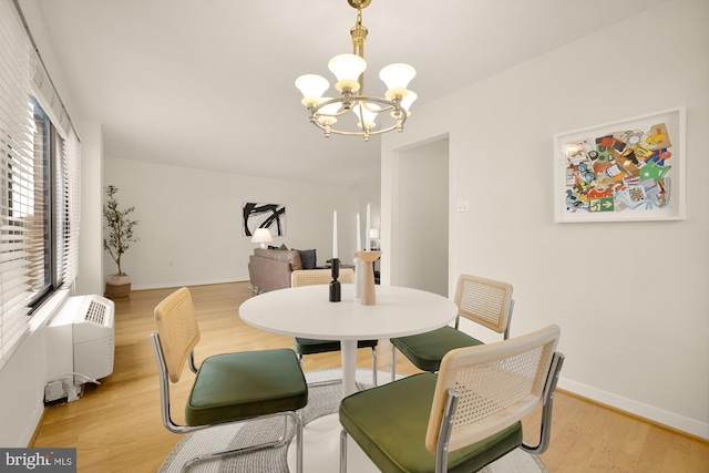 dining area with a wealth of natural light, light hardwood / wood-style flooring, and a chandelier