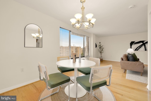 dining area featuring hardwood / wood-style flooring and an inviting chandelier