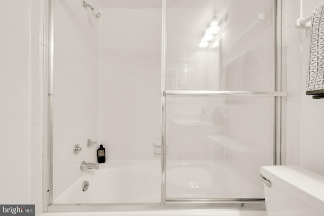 bathroom with shower / bath combination with glass door and toilet