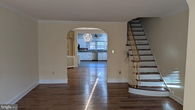 interior space with dark hardwood / wood-style floors, ornamental molding, and a notable chandelier