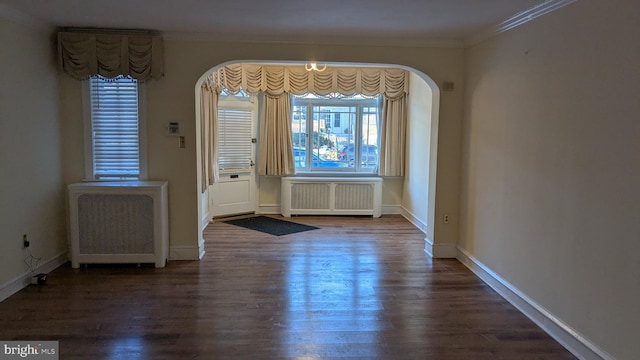 unfurnished dining area featuring radiator, dark hardwood / wood-style floors, and ornamental molding