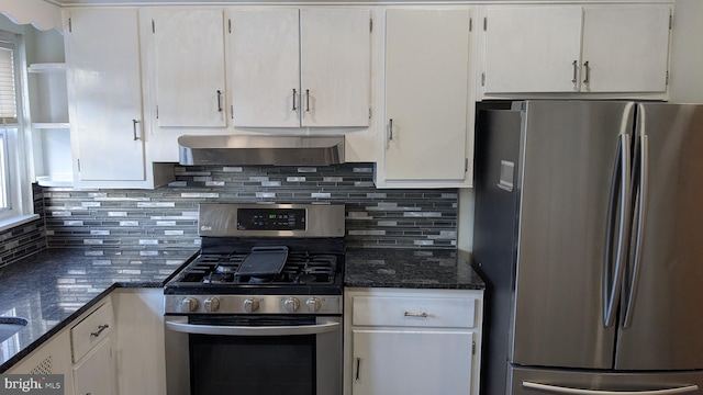 kitchen featuring appliances with stainless steel finishes, ventilation hood, white cabinetry, and dark stone counters