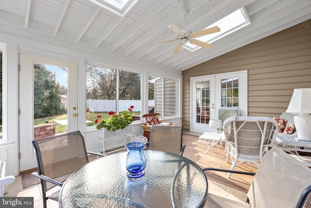 sunroom / solarium with vaulted ceiling with skylight, ceiling fan, plenty of natural light, and french doors