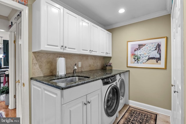 washroom with cabinets, separate washer and dryer, sink, and ornamental molding