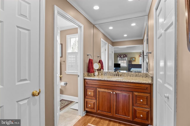 bathroom featuring hardwood / wood-style flooring, vanity, and crown molding