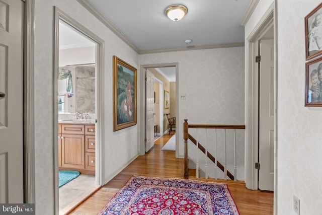 hall featuring crown molding, light hardwood / wood-style flooring, and sink