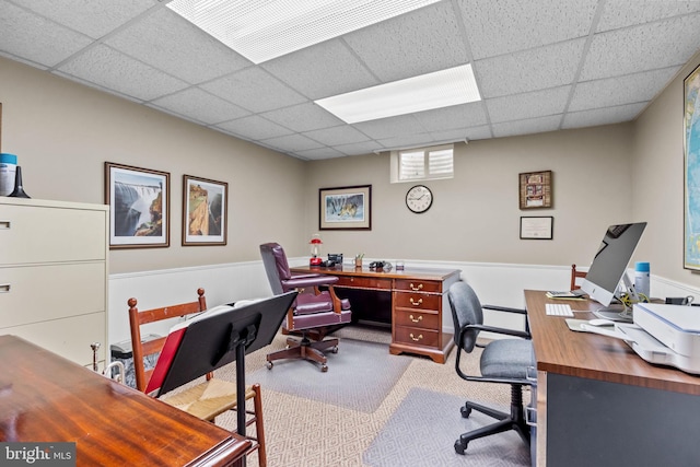 carpeted office space with a drop ceiling