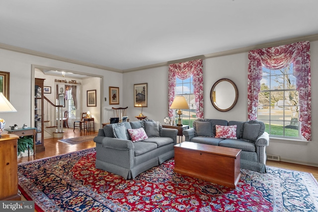 living room featuring crown molding and light hardwood / wood-style flooring