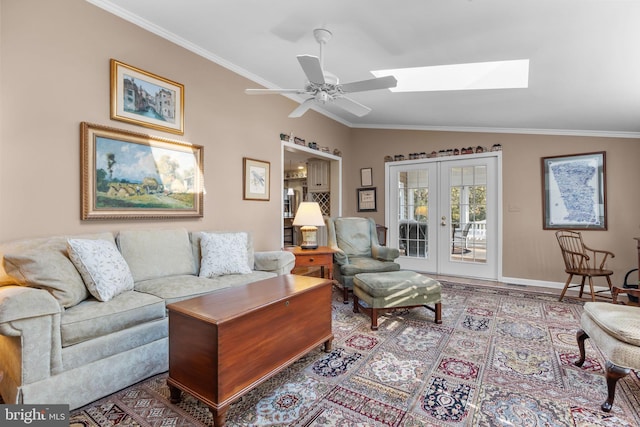 living room with french doors, ceiling fan, crown molding, and vaulted ceiling with skylight