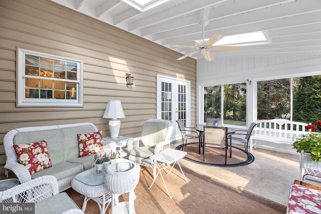 sunroom / solarium with beamed ceiling, ceiling fan, french doors, and a skylight