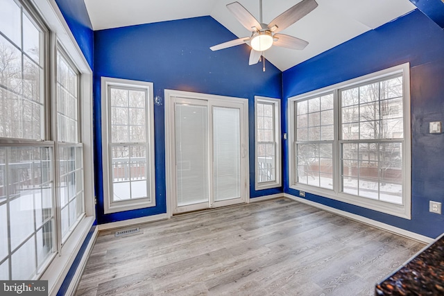 spare room with ceiling fan, plenty of natural light, light wood-type flooring, and vaulted ceiling