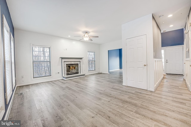 unfurnished living room featuring light hardwood / wood-style flooring and ceiling fan