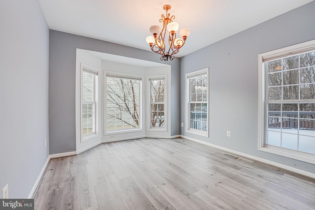 unfurnished dining area featuring light hardwood / wood-style flooring and a notable chandelier