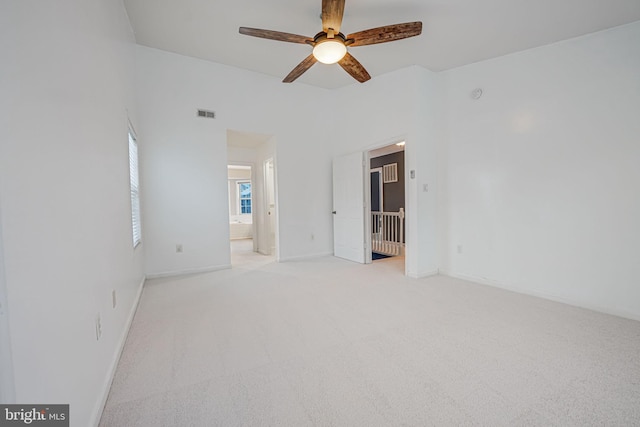 spare room with ceiling fan and light colored carpet