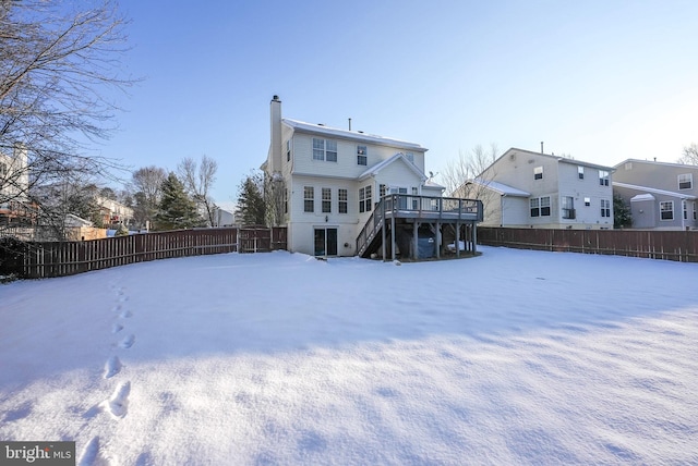 snow covered house featuring a deck