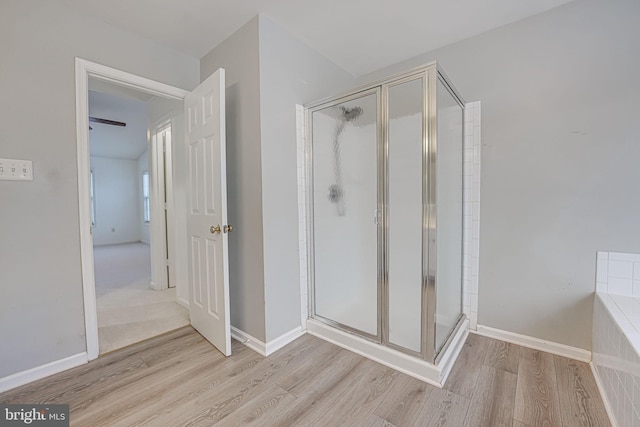 bathroom with hardwood / wood-style floors and a shower with shower door