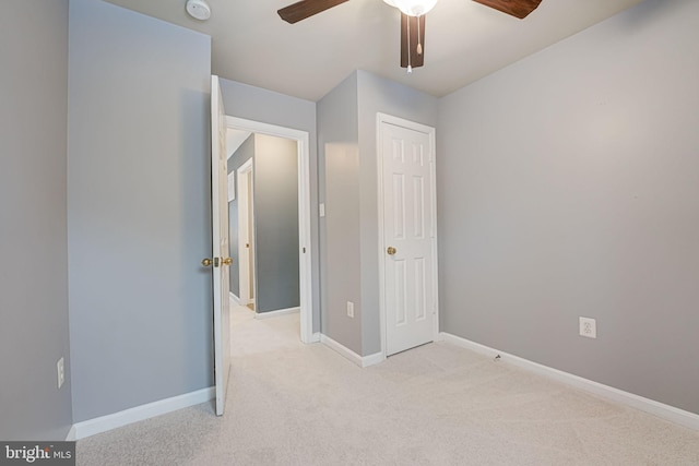 unfurnished bedroom with ceiling fan and light colored carpet