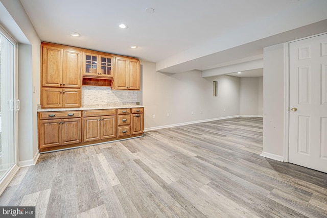 kitchen featuring tasteful backsplash and light hardwood / wood-style flooring