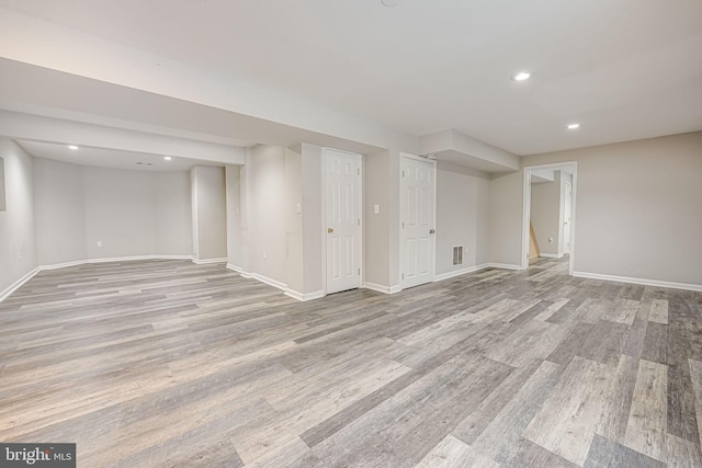 basement with light hardwood / wood-style flooring