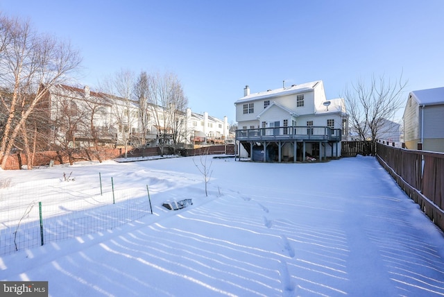 yard layered in snow with a deck