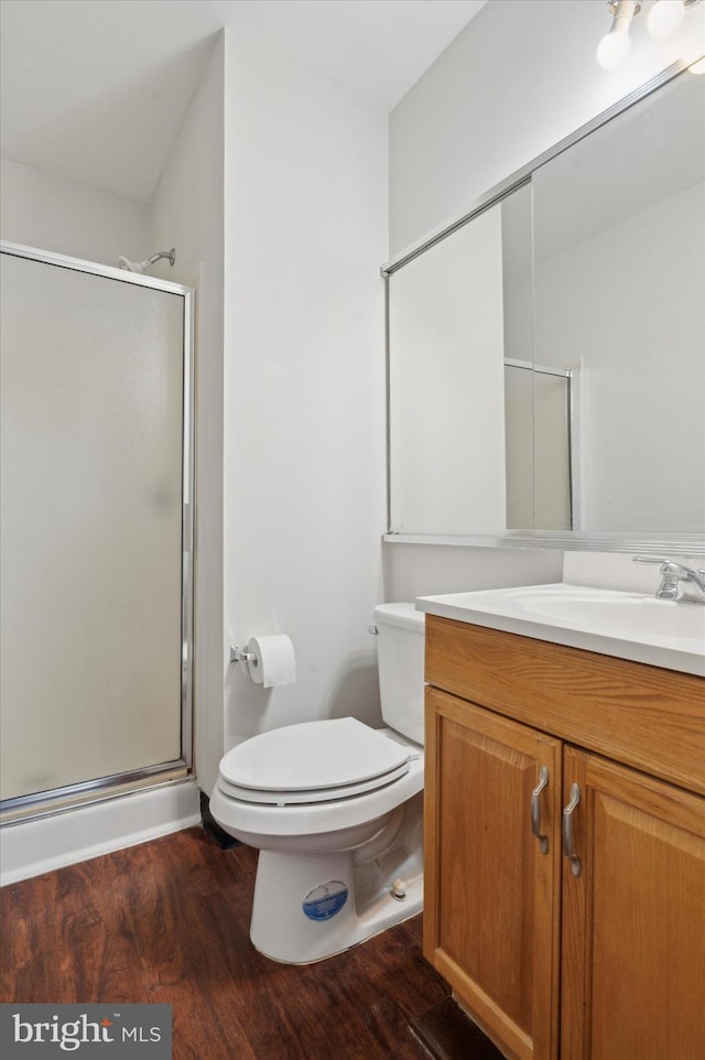 bathroom with hardwood / wood-style flooring, vanity, toilet, and walk in shower