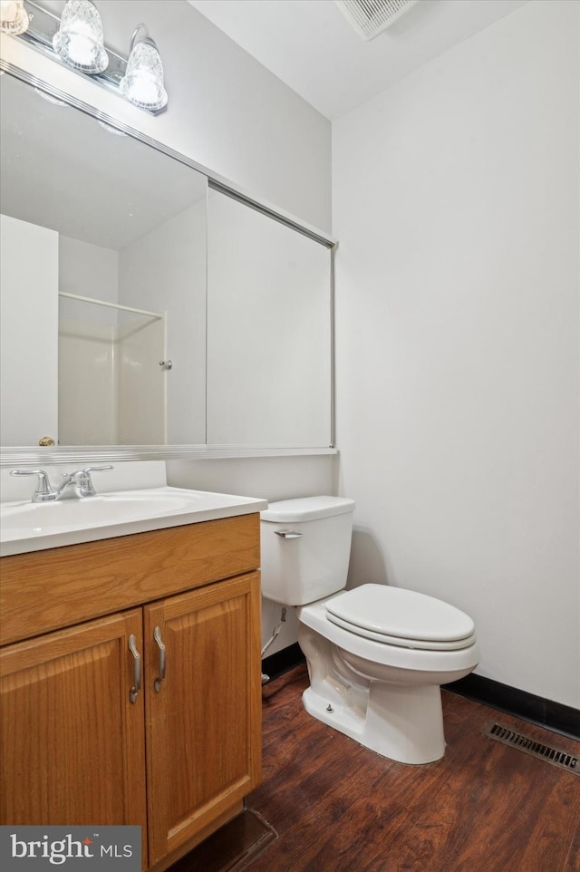 bathroom with vanity, hardwood / wood-style flooring, and toilet