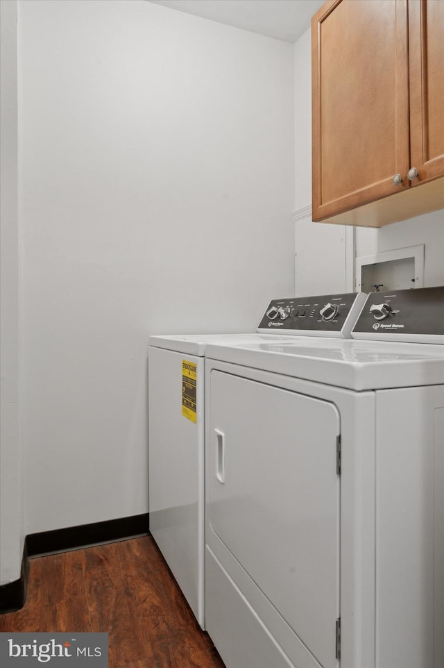 laundry room with separate washer and dryer, cabinets, and dark hardwood / wood-style floors