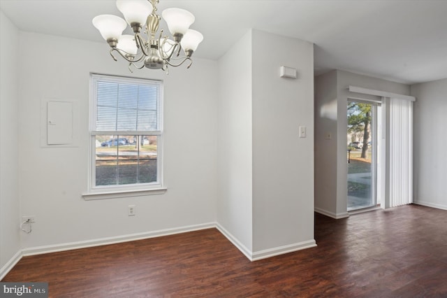 unfurnished room featuring electric panel, dark wood-type flooring, and an inviting chandelier