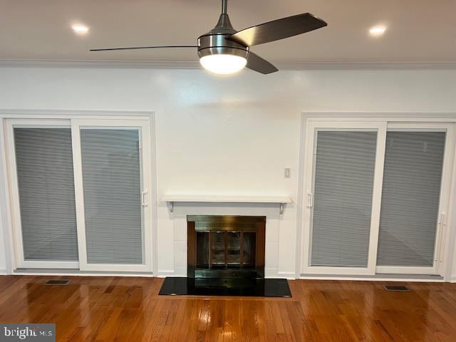 unfurnished living room with hardwood / wood-style flooring, ceiling fan, and ornamental molding