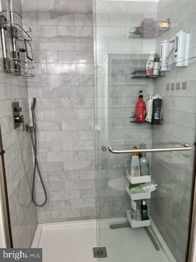 bathroom with a shower with door