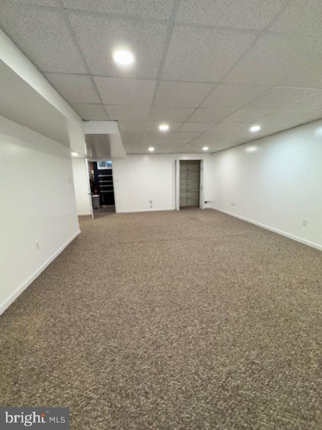 basement with a drop ceiling and carpet floors