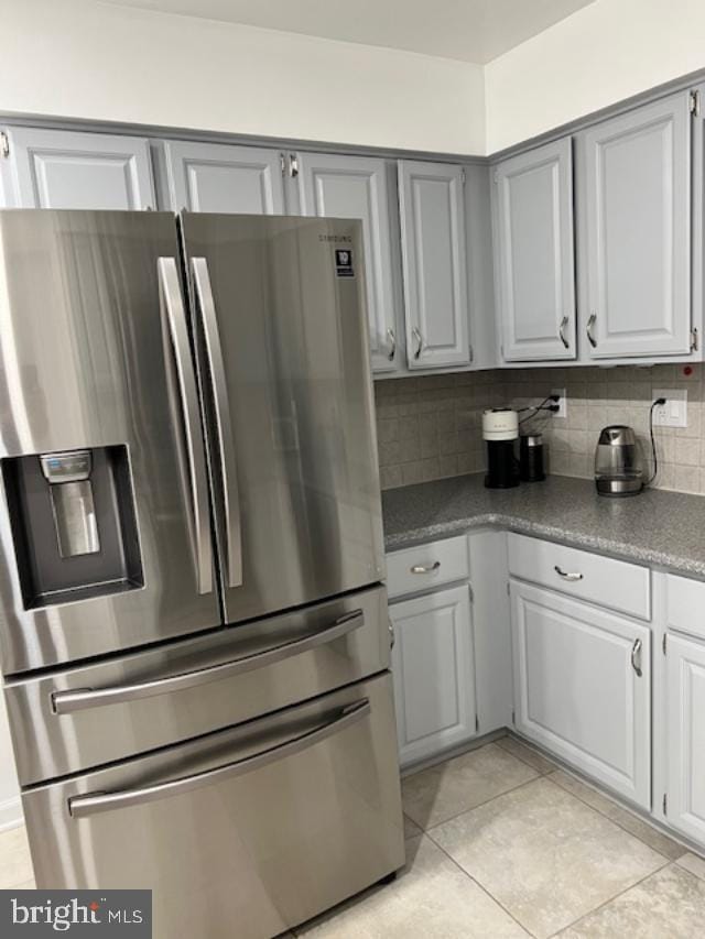 kitchen featuring backsplash, gray cabinetry, stainless steel fridge, and light tile patterned flooring