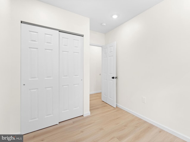 unfurnished bedroom with a closet and light hardwood / wood-style floors