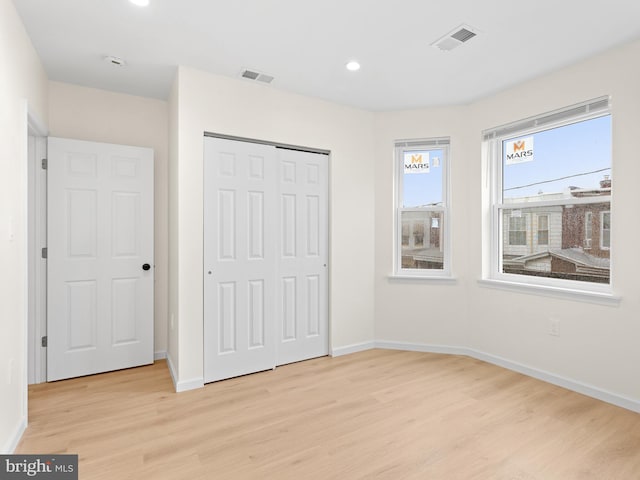 unfurnished bedroom featuring a closet and light hardwood / wood-style floors