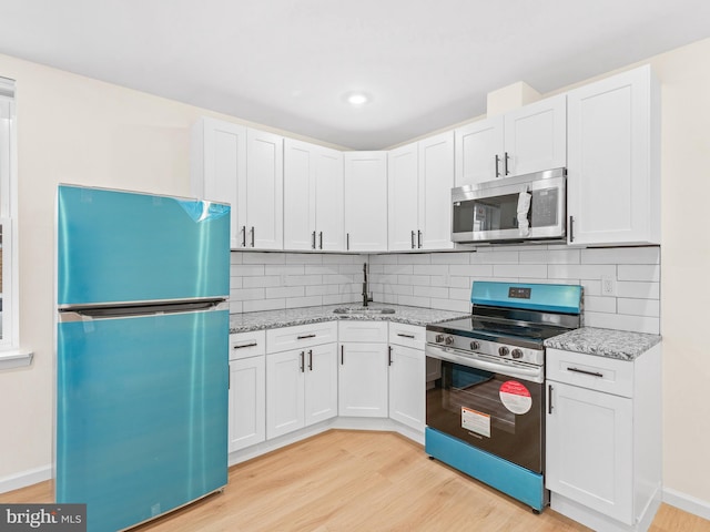 kitchen featuring appliances with stainless steel finishes, tasteful backsplash, and white cabinetry