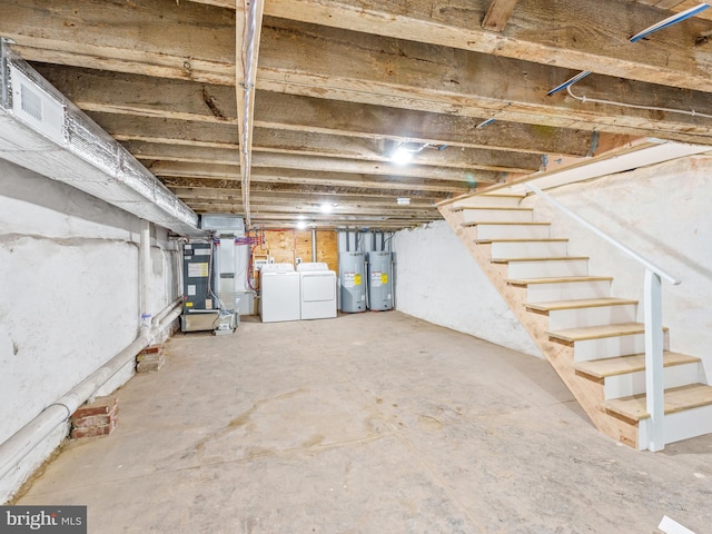 basement with washer and clothes dryer, electric water heater, and heating unit