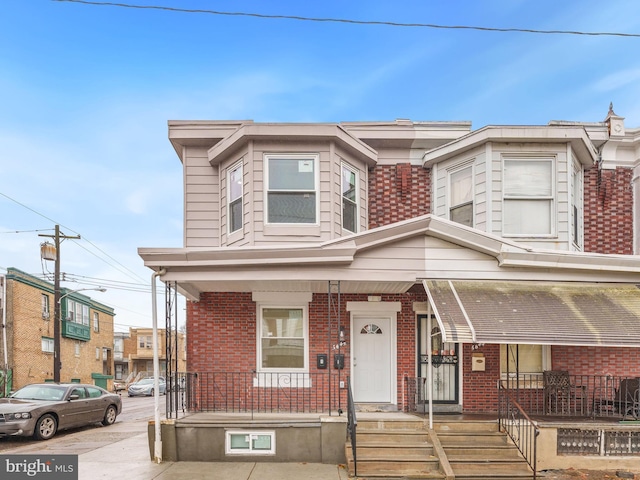 townhome / multi-family property featuring covered porch