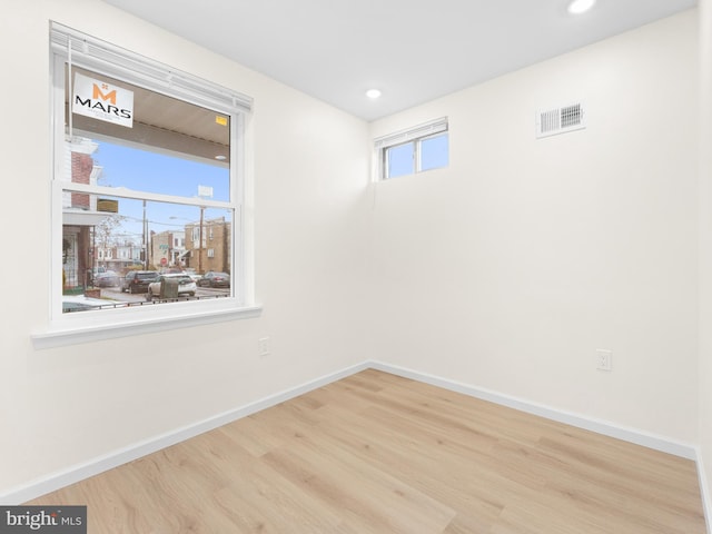 unfurnished room featuring a healthy amount of sunlight and light wood-type flooring