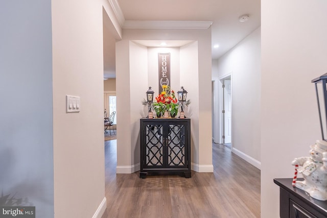 corridor with hardwood / wood-style floors and crown molding