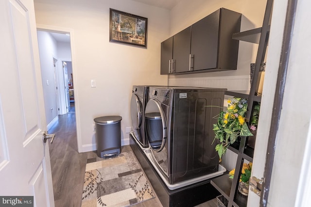 washroom featuring washer and dryer, cabinets, and wood-type flooring