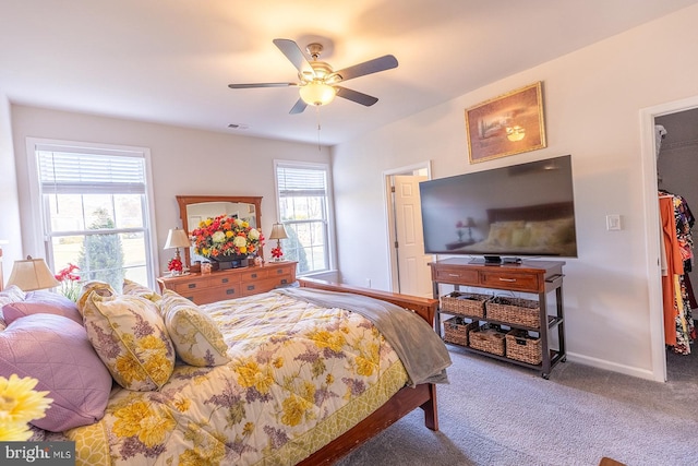 carpeted bedroom with a spacious closet and ceiling fan