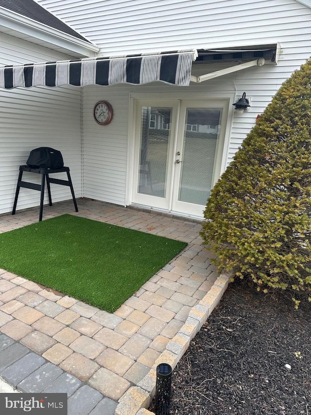 view of exterior entry with a patio and french doors