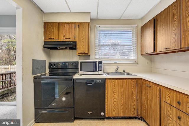 kitchen featuring a healthy amount of sunlight, sink, light tile patterned floors, and black appliances