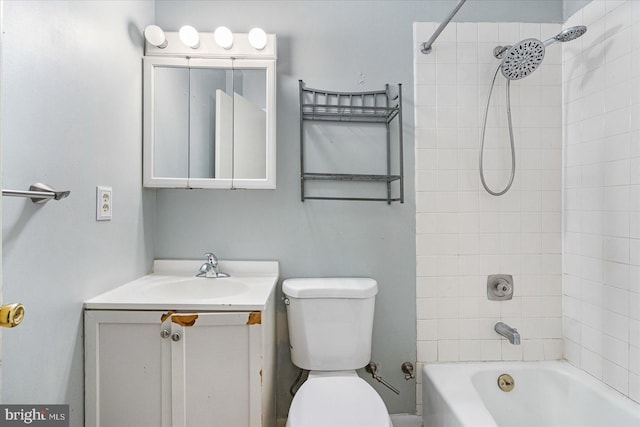 full bathroom featuring tiled shower / bath, vanity, and toilet