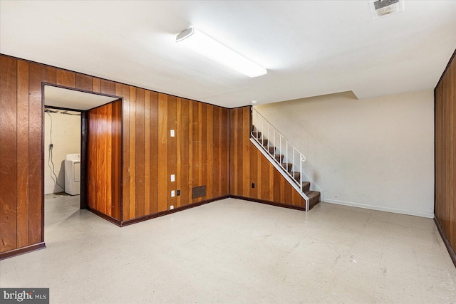 basement featuring washer / dryer and wooden walls