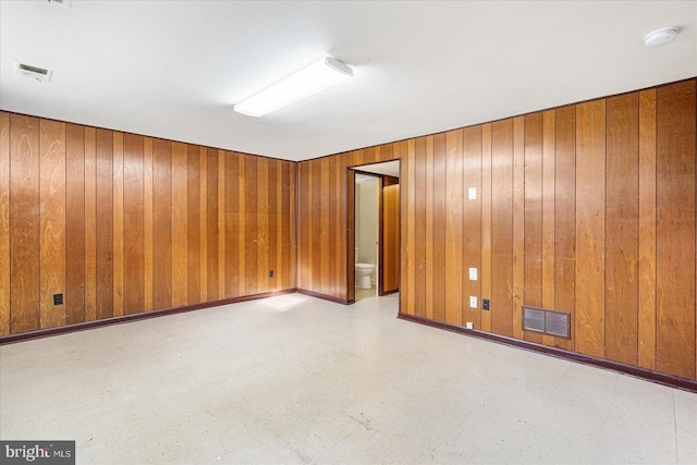 empty room featuring wood walls