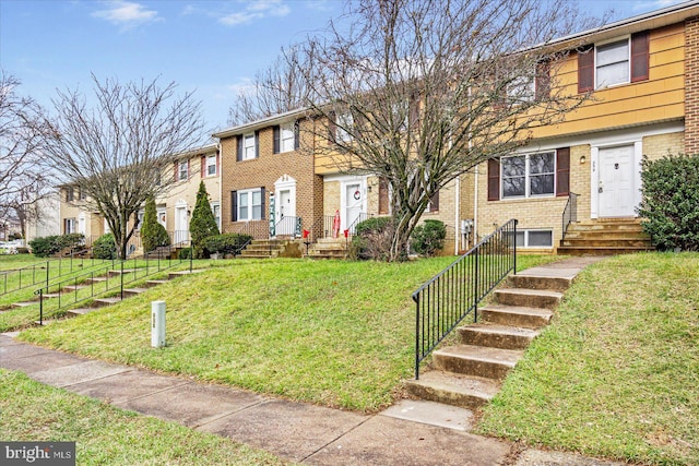 townhome / multi-family property with a front yard