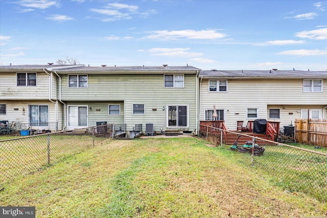 back of property with a lawn and central AC